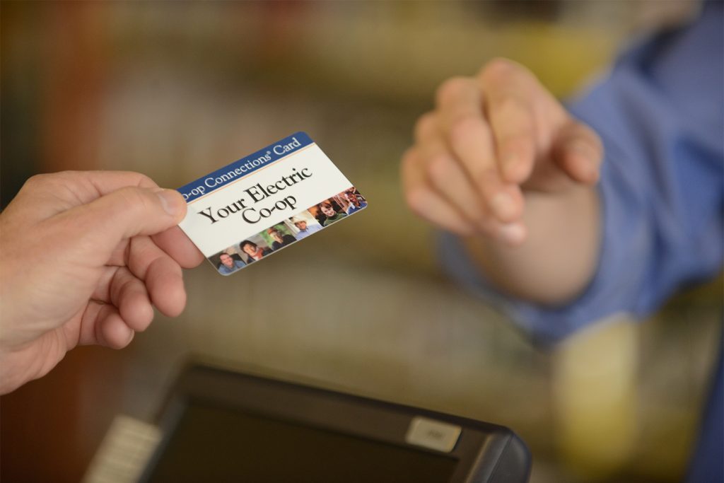 Someone handing a cashier their Co-op Connections Card