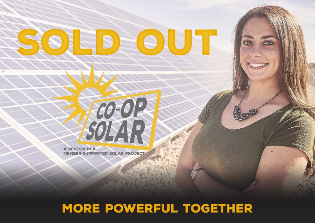 SOLD OUT, Co-op Solar,More Powerful Together - Photo of woman standing next to a community solar farm.