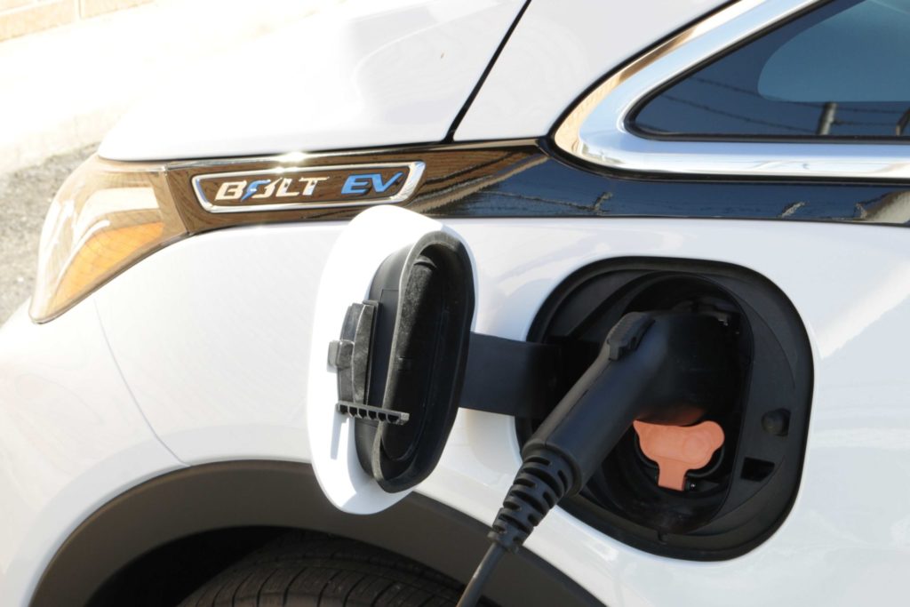 An electric car charger plugged into a Chevy Bolt