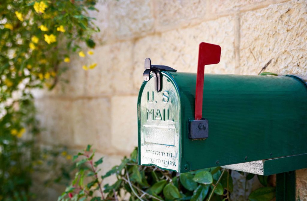 Mail-in ballots - a green mailbox with a red flag up
