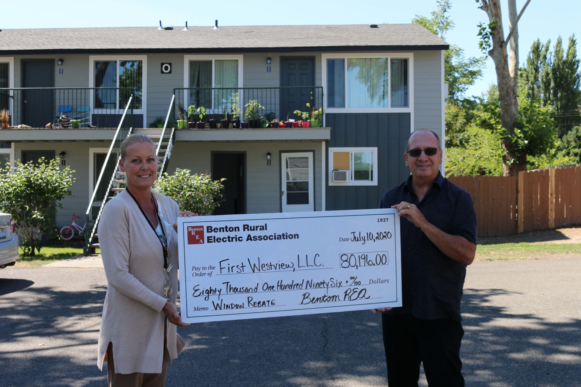 Property Manager Kari Kallio and Owner Don Winton accept a $80,196 window rebate from Benton REA for upgrades to the Westview Gardens Apartments in West Richland.