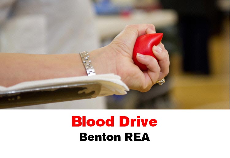 A woman's hand grips a stress ball while giving blood. Text below the image says "Blood Drive Benton REA"