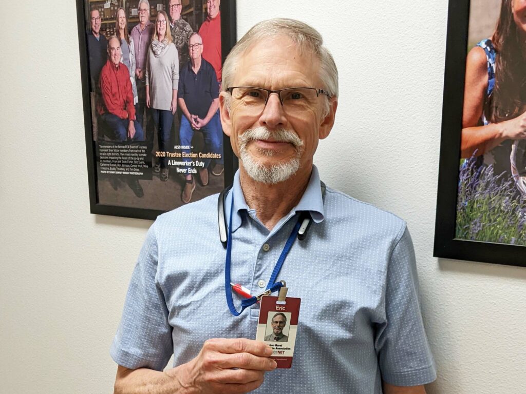 A Benton REA employee holds his ID badge showing that he is not a scam artist.