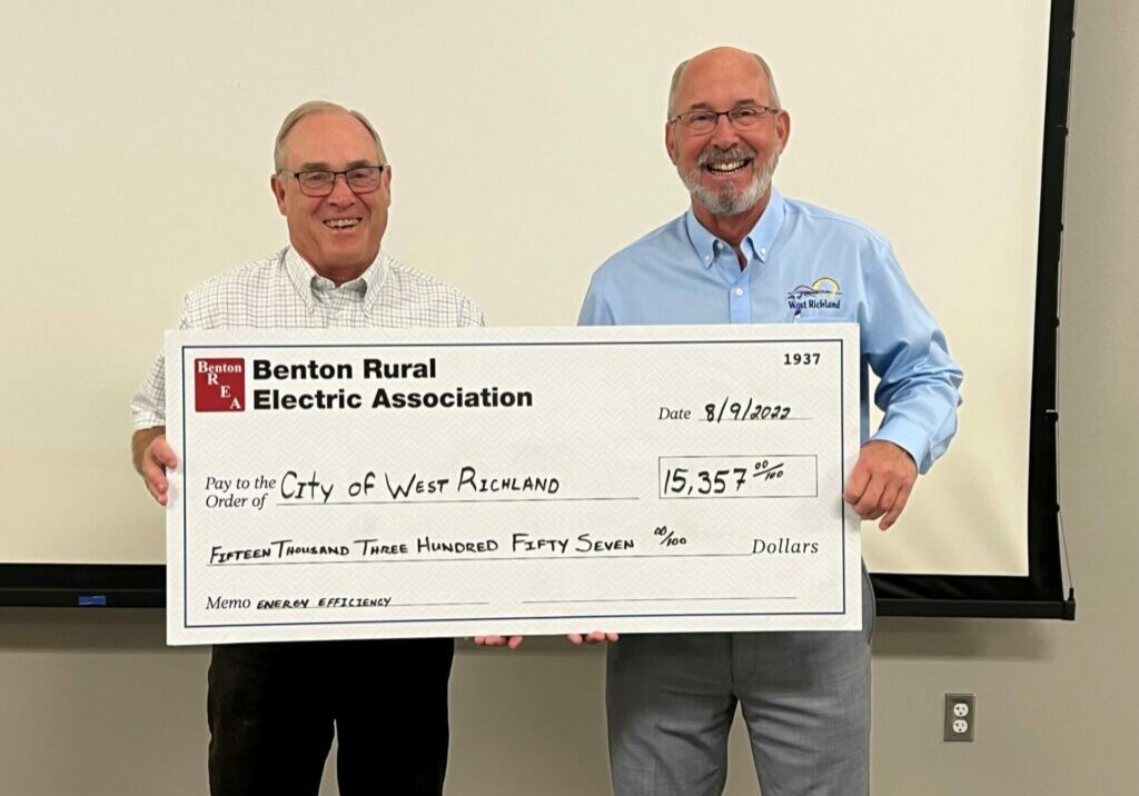 West Richland Mayor Brent Gerry, right, accepts an energy-efficiency incentive check from Bob Evans, vice president of the Benton REA Board of Trustees. PHOTO BY SHANNON OLSEN