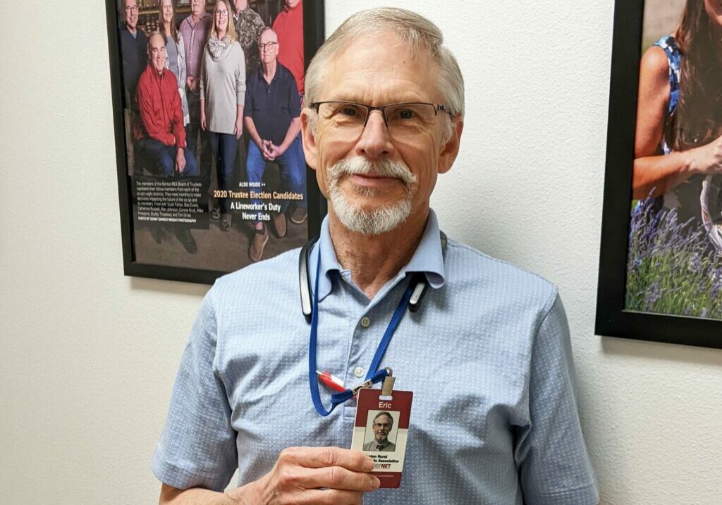 A Benton REA employee holds his ID badge showing that he is not a scam artist.