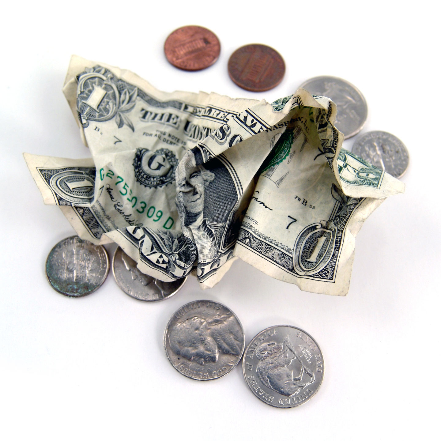 A pile of U.S. coins and a crumpled one dollar bill